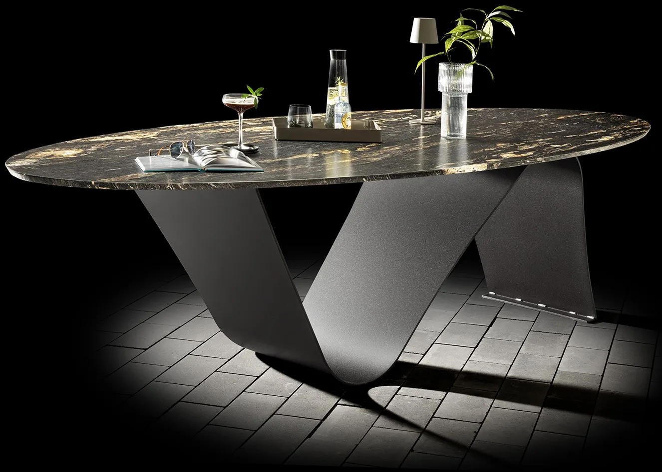 Ovaler Outdoor-Tisch mit dunkler Steinplatte und Designgestell
