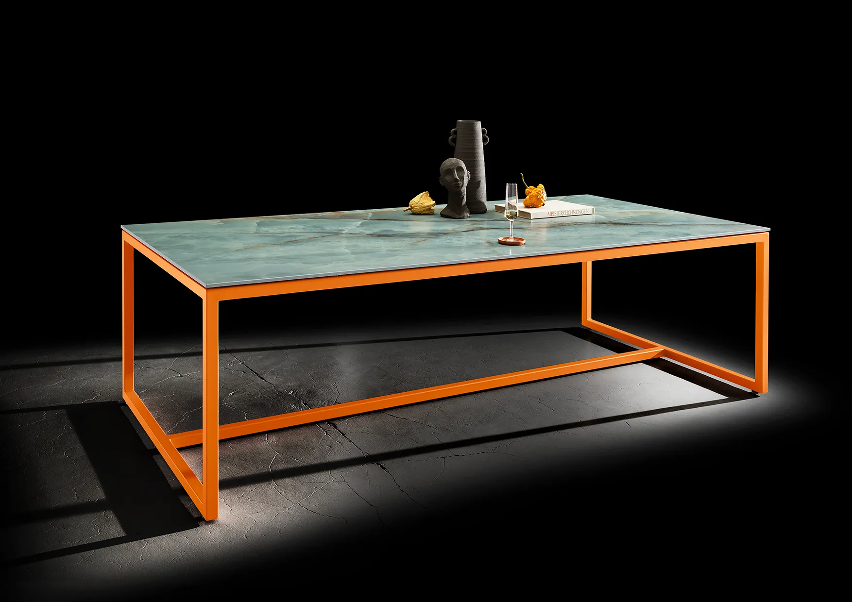 Rechteckiger Outdoor-Tisch mit grün-grauer Keramikplatte und orangefarbenem Gestell